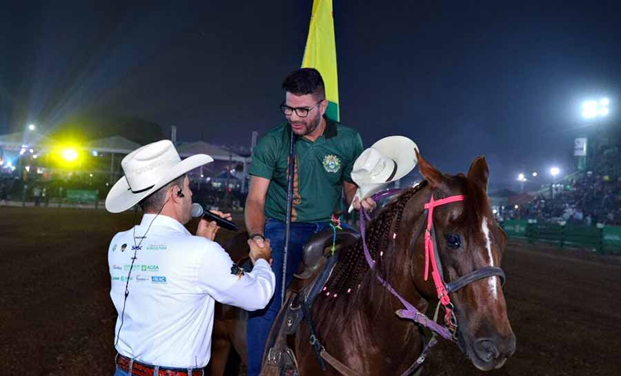 Montado a cavalo e levando a bandeira do Acre, governador Gladson Cameli participa da abertura do rodeio